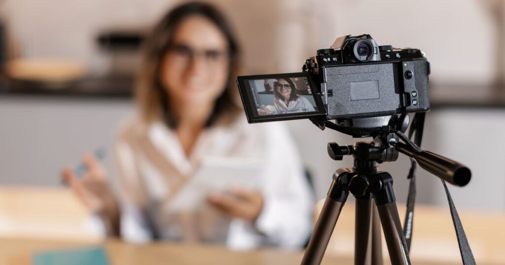 Creadora grabando un vídeo con cámara y trípode para YouTube