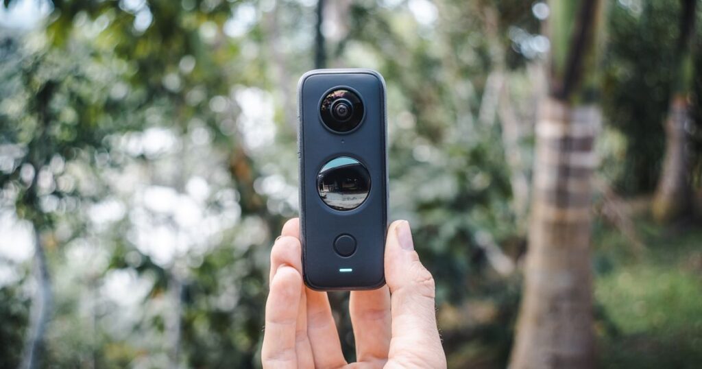 Cámara 360 compacta sostenida en la mano al aire libre