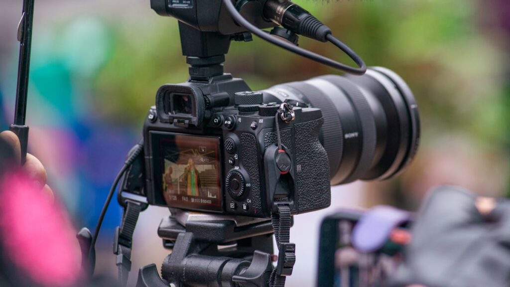cámara con micrófono lista para grabar a una persona hablando con teleprompter