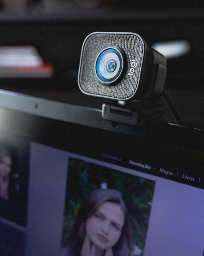 Webcam put on display of netbook and connected to Internet at modern workplace